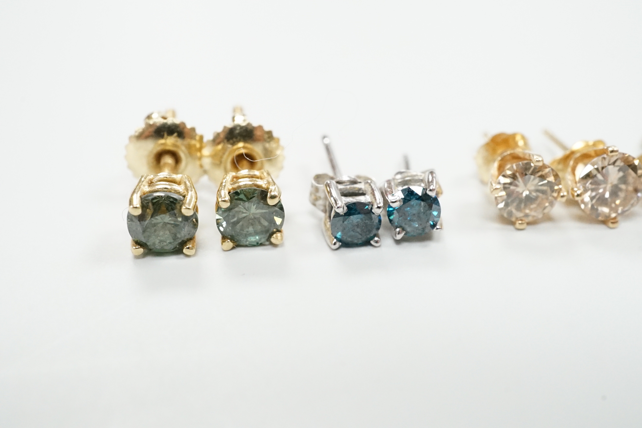 Four assorted pairs of yellow or white metal and diamond set ear studs, including coloured stones.